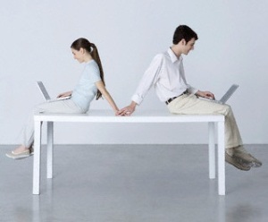 Couple Sitting Back to Back, Using Laptop Computers, Holding Hands